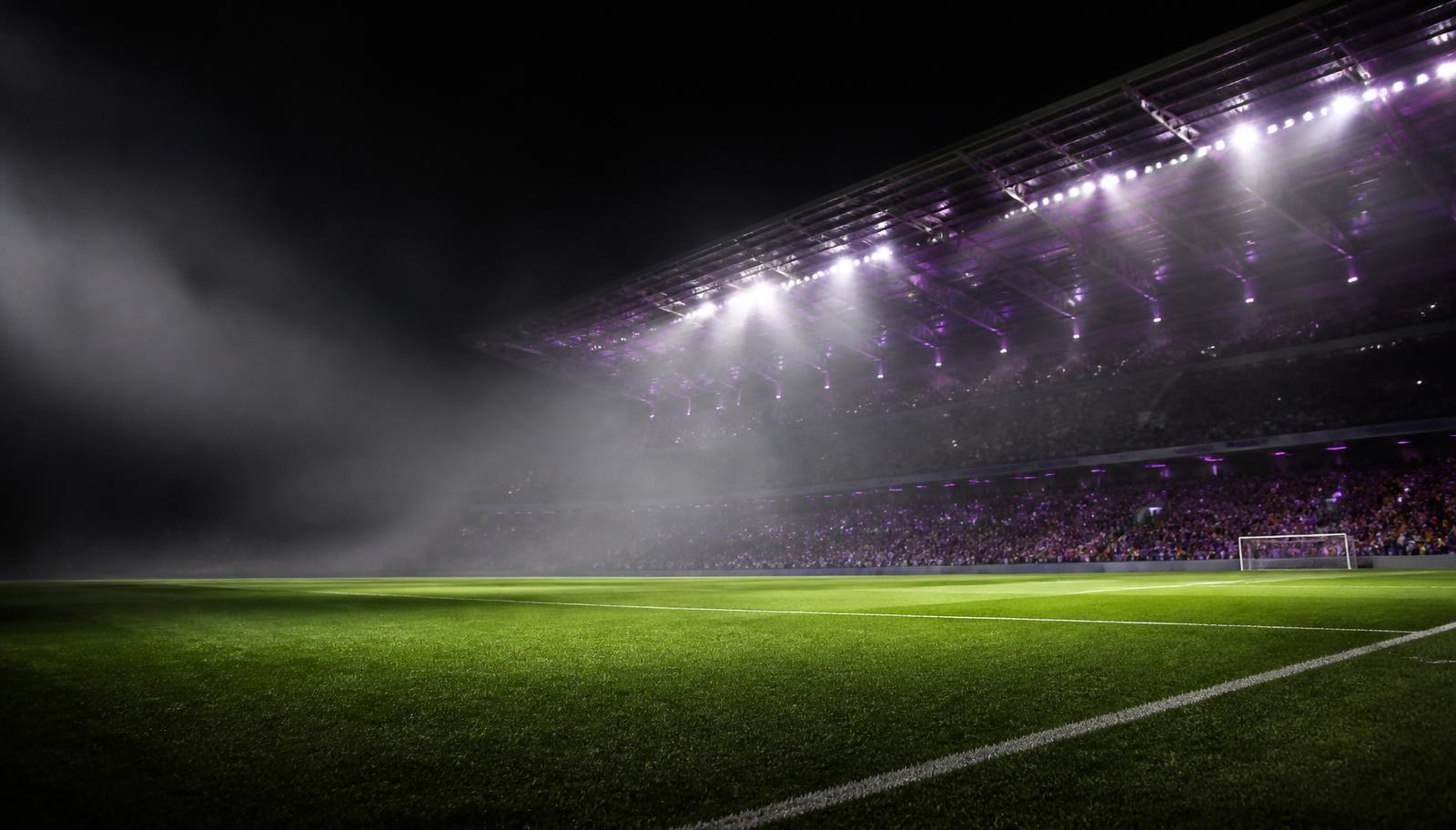 Floodlit football stadium at night
